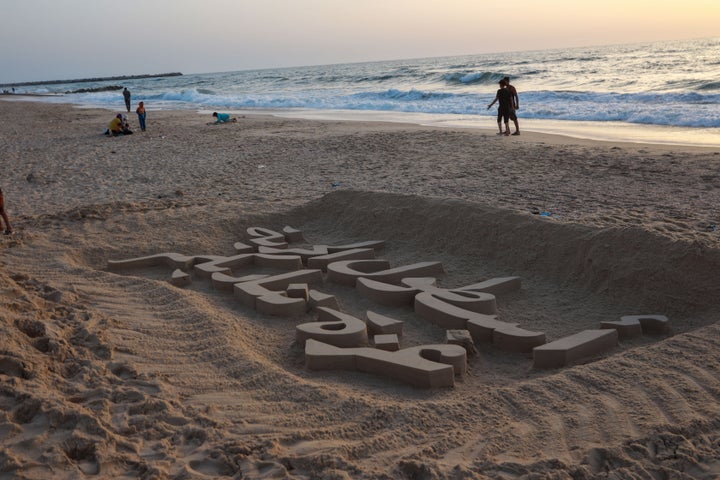 Palestinian artist Yezid Abu Jerad creates a sand sculpture reading, "Freedom Flotilla Gaza is Calling You" on a beach next to a tent camp in Gaza on May 19, 2026. The artwork was crafted to voice solidarity and show support for the Global Sumud Flotilla, whose activists from dozens of countries were detained by Israel for trying to break the ongoing blockade and deliver vital humanitarian aid to the region.