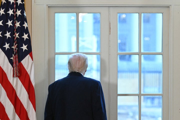 President Donald Trump looks through a window to observe construction work on his new ballroom during a meeting with oil company executives in January.