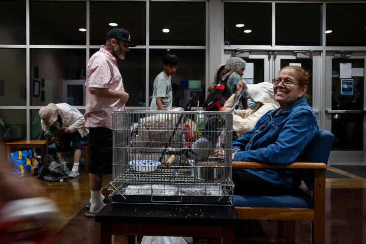 Angie Mallon, an evacuee from an aerospace chemical plant tank leak, exits the Garden Grove Sports and Recreation Center with her pet pigeon in Garden Grove, Calif., Friday, May 22, 2026. (AP Photo/Ethan Swope)
