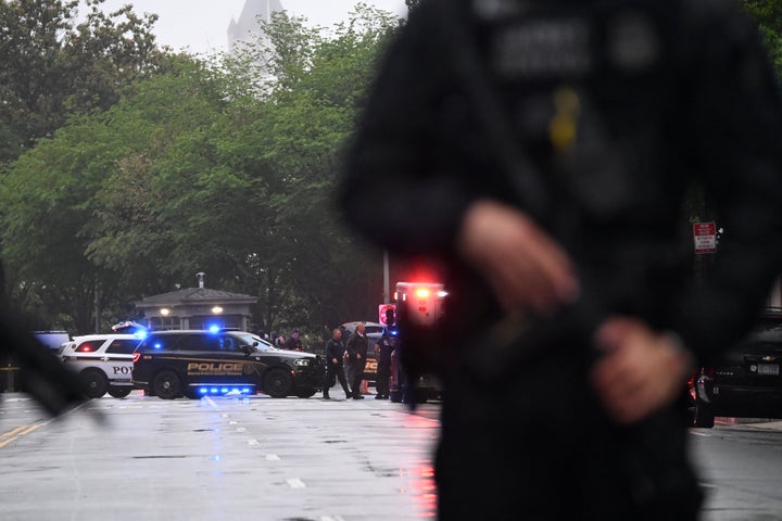 Police vehicles and armed officers are seen near the White House in Washington, DC, on May 23, 2026. Police and security forces swarmed the area around the White House on the evening of May 23 after reports of shots fired, AFP journalists said. US President Donald Trump was at the White House at the time as he worked to negotiate a deal with Iran. (Photo by Alex WROBLEWSKI / AFP via Getty Images)