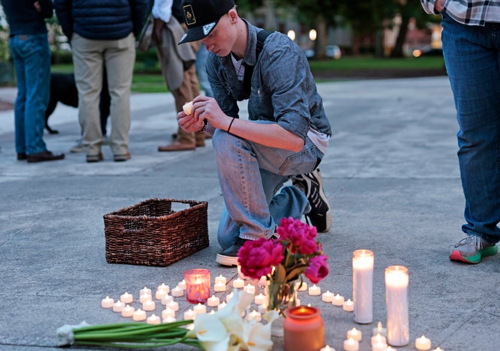 Kaeden Beck, 16, lays down electric candles during an evening prayer and vigil, in support for the victims and their families impacted by Nippon Dynawave Packaging Co. tank implosion, at R.A. Long Park in Longview, Wash., on Tuesday, May 26, 2026. (Karen Ducey /The Seattle Times via AP)