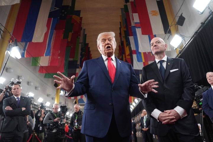 Trump, left, speaks to the press alongside Infantino, right, after arriving at the Kennedy Center for the World Cup draw event in December.