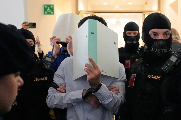 FILE - The defendants hide their faces behind file folders on their way to the courtroom in the District Court in Wiener Neustadt, Austria, where two terror suspects will stand trial Tuesday, one for plotting to carry out an attack on one of superstar singer Taylor Swift's concerts in Vienna in August 2024 and pledging allegiance to the Islamic State group, Tuesday, April 28, 2026. (AP Photo/Matthias Schrader, File)