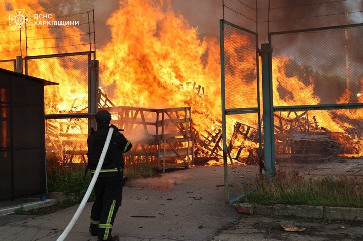 In this photo provided by Ukrainian Emergency Services on June 2, 2026, a rescue worker extinguishes a fire at a storage facility following the Russian attack on Ukraine's Kharkiv region.