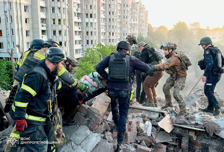 In this photo provided by Ukrainian Emergency Services on June 2, 2026, rescue teams carry an injured woman on a stretcher from the rubble of a collapsed residential building after the Russian attack on the Dnipropetrovsk region of Ukraine.