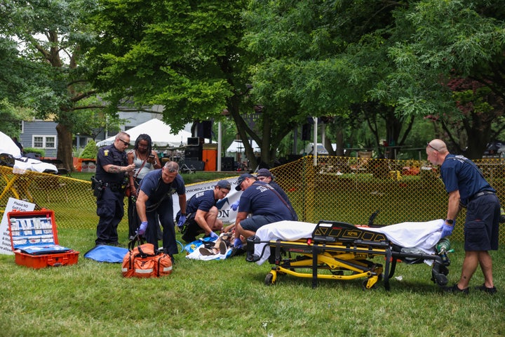 First responders help a woman who was injured the mass shooting that left 12 people injured at the Old West End Festival at the Agnes Reynolds Jackson Arboretum in Toledo on Saturday, June 6, 2026. (Rebecca Benson/The Blade via AP)