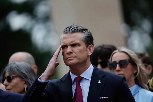 Pete Hegseth salutes during a ceremony at the US cemetery to commemorate the 82nd anniversary of D-Day.