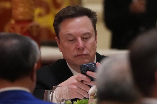 Elon Musk uses his phone during a state dinner for President Donald Trump and Chinese President Xi Jinping at the Great Hall of the People on Thursday May 14, 2026, in Beijing. (AP Photo/Mark Schiefelbein)