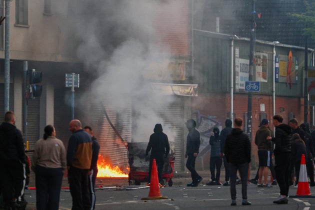 A building is set light to by protesters in central Belfast following a stabbing incident in Belfast, Tuesday, June 9, 2026. (AP Photo/Peter Morrison)
