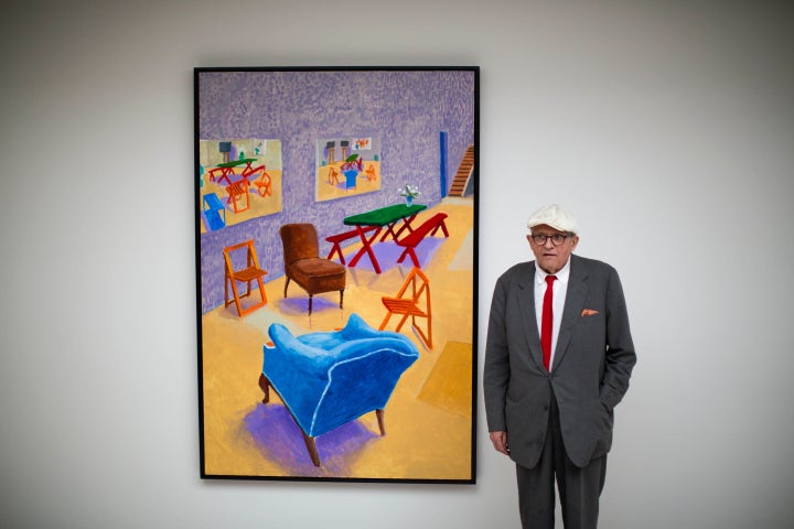 David Hockney posing with one of his art pieces in 2015