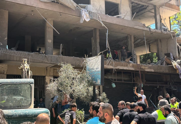People gather at the site of an Israeli airstrike that struck an apartment in Dahiyeh, Beirut's southern suburbs, Lebanon, Sunday, June 14, 2026. (AP Photo/Bilal Hussein)