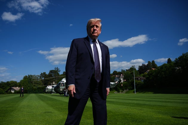 President Donald Trump walks towards reporters as he arrives for the G7 summit.