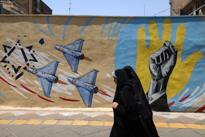 Women walk past an anti-U.S. and anti-Israeli mural in Tehran on June 3, 2026. That day, the military adviser to Iran's Supreme Leader warned of more missile and drone strikes should the United States renew its attacks on Iran.