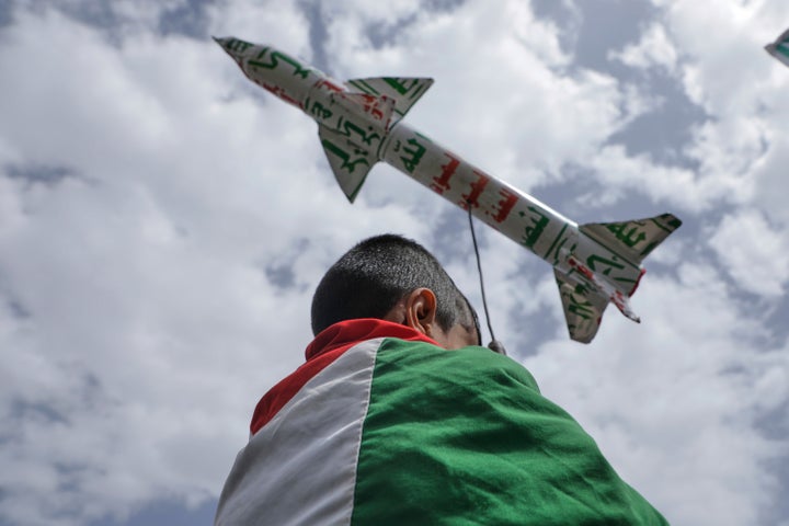 A boy draped in a Palestinian flag carries a mock rocket during a weekly anti-U.S. and anti-Israel rally organized by Houthi supporters in Sanaa, Yemen, on May 9, 2025.