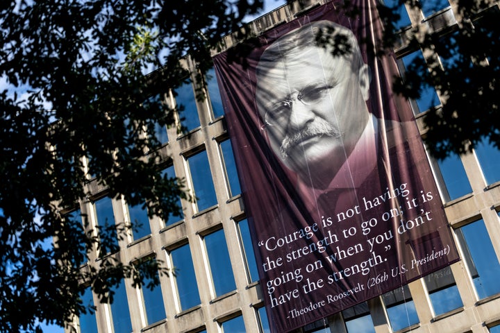 A banner reading, "Courage is not having the strength to go on; it is going on when you don't have the strength," with a photo of Theodore Roosevelt, is hung outside the Theodore Roosevelt Federal Building on June 15 in Washington, D.C.
