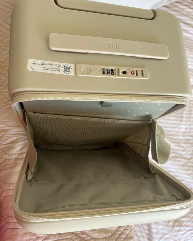 The suitcase with just the front pocket open.