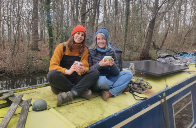 The author (right) having a cup of tea with a houseboat dweller while cruising up the canal.