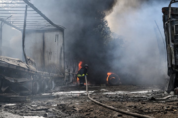 A rescuer pulls a hose during a response effort to a fire at a parking lot in Zaporizhzhia, Ukraine, on June 25, 2026. The area is affected by Russian drone strikes, which targeted a petrol station, Ukrzaliznytsia (Ukrainian Railways) locomotives, and a parking lot. 