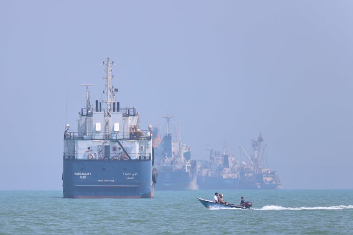 A small motorboat passes anchored vessels in the Strait of Hormuz off Bandar Abbas, Iran, Thursday, June 11, 2026.(Amirhosein Khorgooi/ISNA via AP)