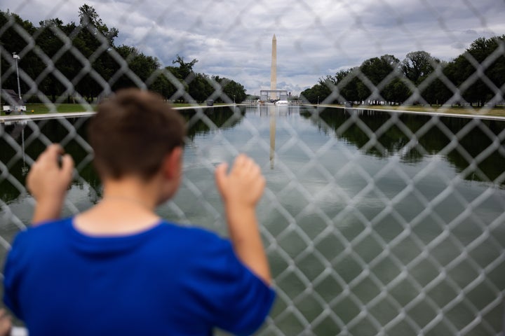 A child looks at the Lincoln Memorial Reflecting Pool from behind a fence on June 27, 2026, in Washington, D.C.