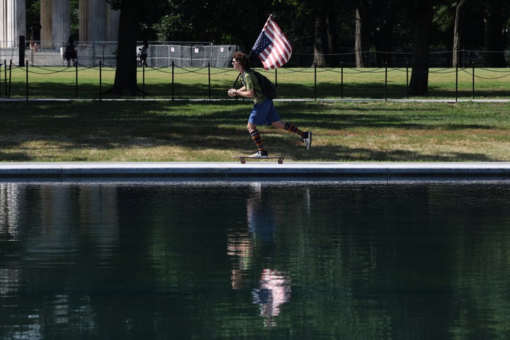 A skateboarder carries an upside down American flag while circling the Lincoln Memorial Reflecting Pool on June 25. Though President Donald Trump poured $15 million into renovating the landmark, his project seems to have backfired spectacularly.