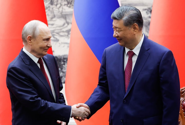 Russian President Vladimir Putin, left, and Chinese President Xi Jinping shake hands during a signing ceremony at the Great Hall of the People in Beijing, on May 20, 2026.