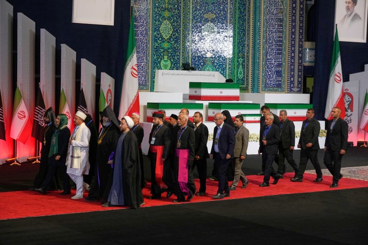 Foreign religious leaders and other mourners walk past the coffins of slain Iranian Supreme Leader Ayatollah Ali Khamenei and members of his family during a viewing ceremony ahead of the dayslong funeral ceremonies at the Imam Khomeini Mosalla Grand Mosque in Tehran, Iran, on July 3, 2026. 