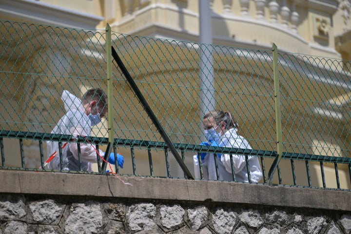 Investigators examine the scene at the residential building where an explosive device seriously injured three people a day earlier in Monaco, on June 30, 2026.