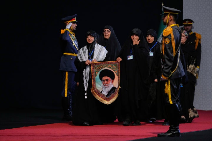 Women carry a portrait of slain Iranian Supreme Leader Ayatollah Ali Khamenei as they arrive to pay their respects before the coffins of Khamenei and members of his family during a viewing ceremony ahead of the dayslong funeral ceremonies at the Imam Khomeini Mosalla Grand Mosque in Tehran, Iran, on July 3, 2026.