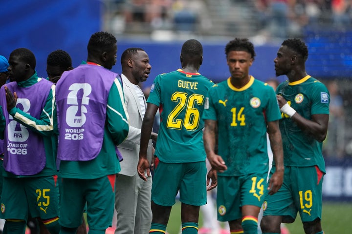 Senegal head coach Pape Thiaw talks with his players during a hydration break of the World Cup round of 32 soccer match between Belgium and Senegal in Seattle.