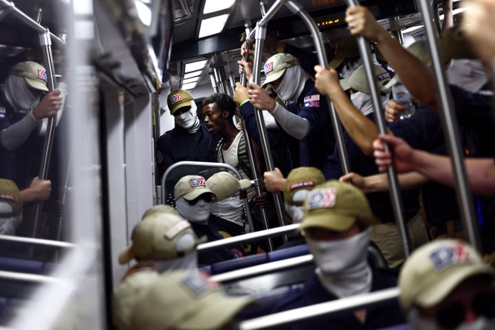A passenger looks on as members of the white supremacist group Patriot Front ride the Washington Metro on Saturday in Washington, D.C. 