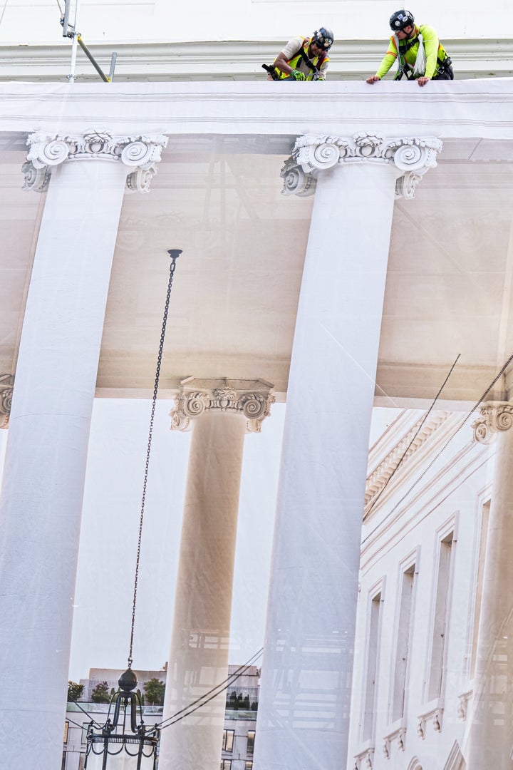 Workers put up a tarp to cover the scaffolding on the North Portico of the White House, Thursday, July 9, 2026, in Washington. (AP Photo/Julia Demaree Nikhinson)