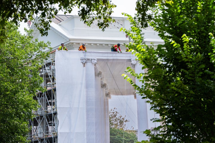 Workers put up a tarp to cover the scaffolding on the North Portico of the White House, Thursday, July 9, 2026, in Washington. (AP Photo/Julia Demaree Nikhinson)