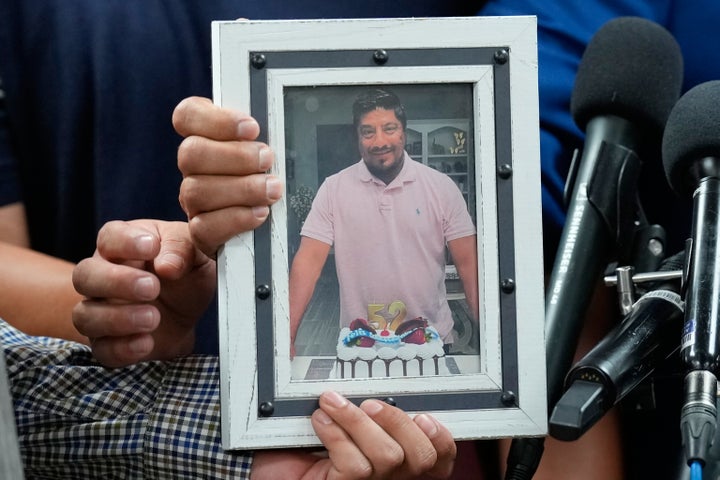 Ronaldo Salgado and Lorenzo Jr., sons of Lorenzo Salgado Araujo, hold a photograph of their father during a news conference Wednesday, July 8, 2026, in Houston.