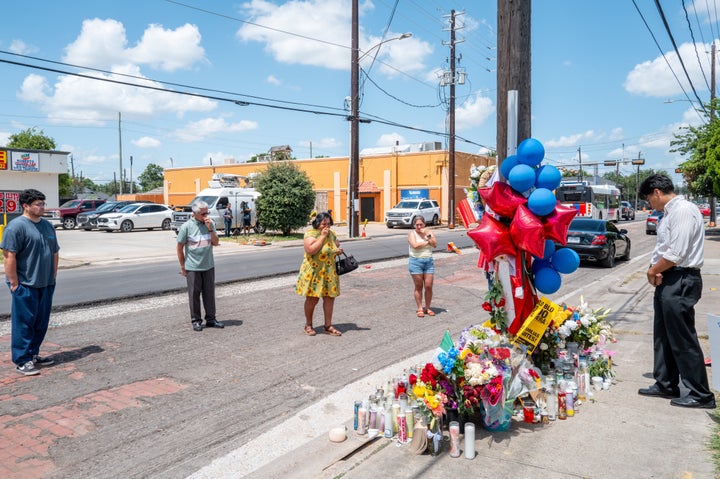 Lorenzo Salgado Jr. (R) pays his respects at the site where his father was killed on July 9, 2026 in Houston, Texas. 