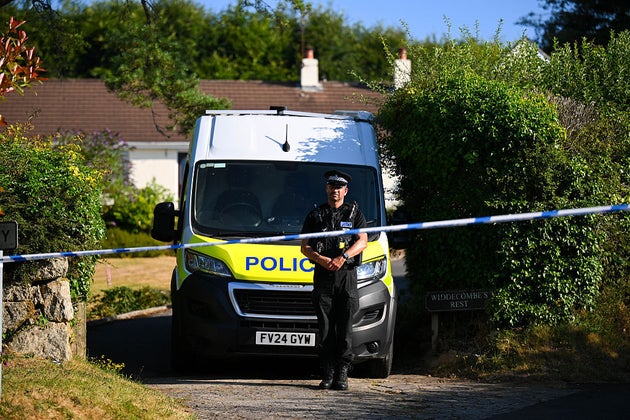 A police officer stands outside the house of Ann Widdecombe in Haytor.