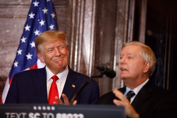 President Donald Trump smiles in 2023 as Sen. Lindsey Graham (R-S.C.) addresses the crowd during an election campaign event in Columbia, South Carolina.