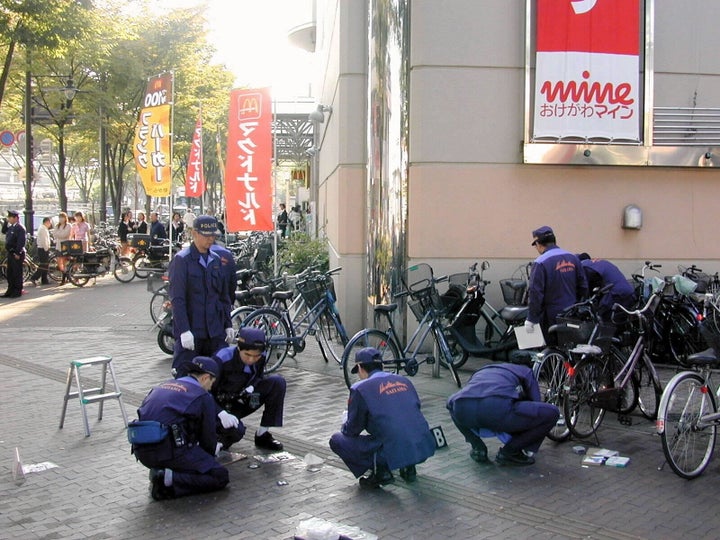 女子が刺殺されたJR桶川駅前で現場検証する捜査員(1999年10月26日、埼玉県桶川市)