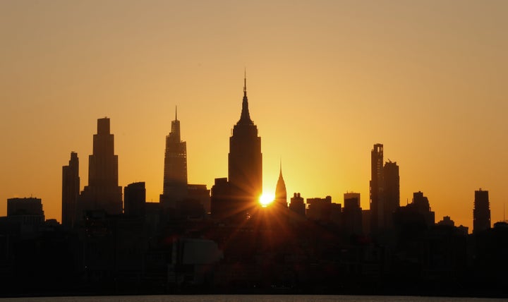 The sun rises behind the skyline of midtown Manhattan and the Empire State Building in New York City as smoke from wildfires from Canada moves into the region on July 15, 2026, as seen from Jersey City, New Jersey. (Photo by Gary Hershorn/Getty Images)