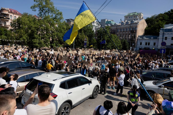 Protesters chant slogans and wave a Ukrainian national flag as they take part in a demonstration against Ukraine's President Volodymyr Zelenskyy's decision to dismiss Defense Minister Mykhailo Fedorov, in Kyiv on July 16, 2026.