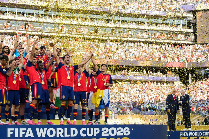The Spanish team celebrates their win as Infantino and Trump speak to the side. 