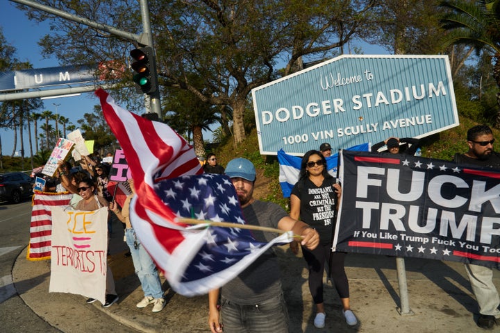 Protestors wave flags and display signs during a game day demonstration outside Dodger Stadium on June 21, 2025.