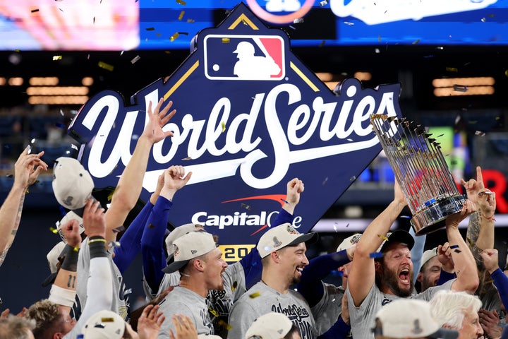 Pitcher Clayton Kershaw raises the Commissioner's Trophy after the team’s championship winning game last fall.