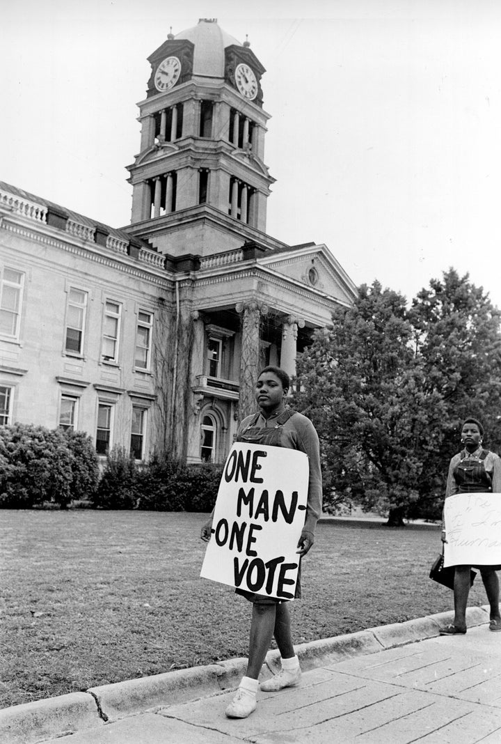 Civil rights supporters stage a peaceful mass voter-registration picket at the County Courthouse in Greenwood, Miss., on March 25, 1964. About 90 black and white picketers paraded in front of the courthouse while Greenwood police watched.