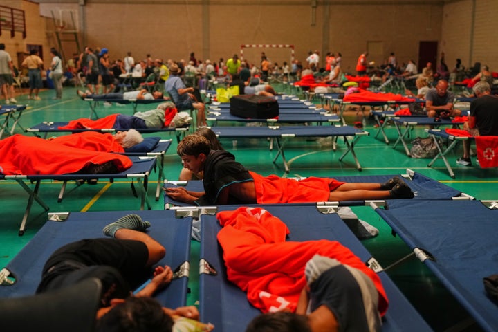 Residents who were evacuated from their homes due to fire danger in Cebreros, Spain's Ávila province, spent the night in a sports center on Friday, July 24, 2026. (AP Photo/Manu Fernandez)