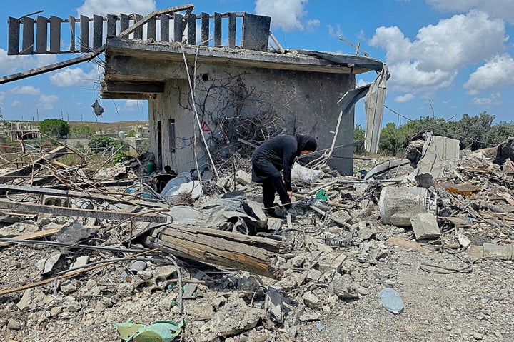 A Lebanese woman clears the debris of her destroyed house in the village of Zawtar al-Gharbiyeh, southern Lebanon, Sunday, July 26, 2026. (AP Photo/Ahmad Mantash)