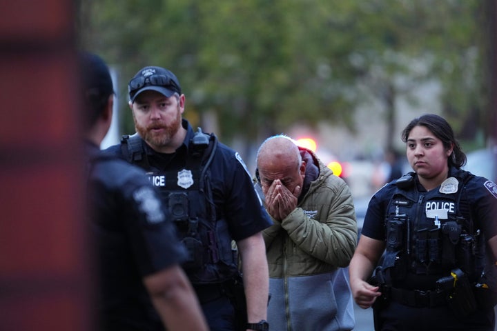 Police lead an unidentified man to the scene of the attack.