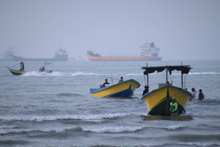 Small boats line the shore as cargo ships and other commercial vessels appear anchored in the Strait of Hormuz off Bandar Abbas, Iran, on July 27, 2026.