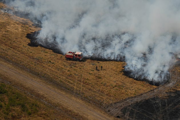Firefighters work to suppress a fire near Ares, during wildfires in the area of southwestern France, Tuesday, July 28, 2026.