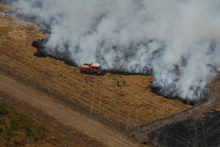 Firefighters work to suppress a fire near Ares, during wildfires in the area of southwestern France, Tuesday, July 28, 2026.